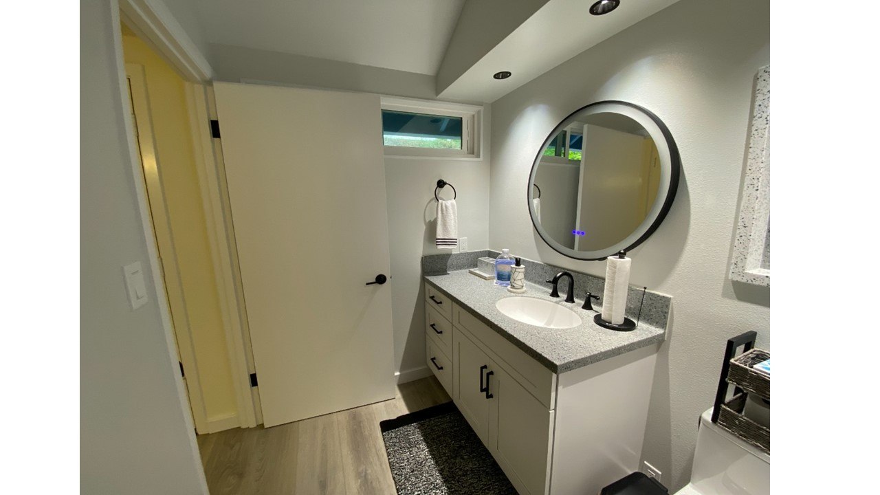 A bathroom with a sink, mirror, and a towel rack.